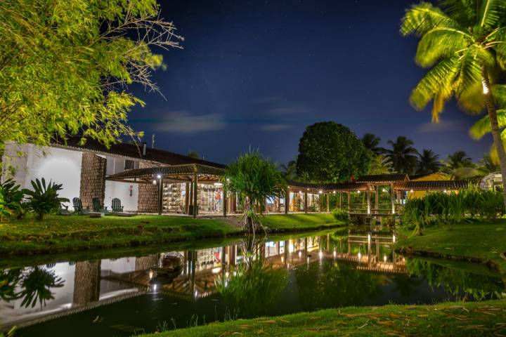 Uma casa com um lago na frente à noite.