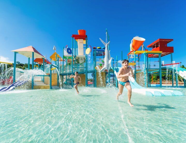 Duas crianças estão brincando em um parque aquático.