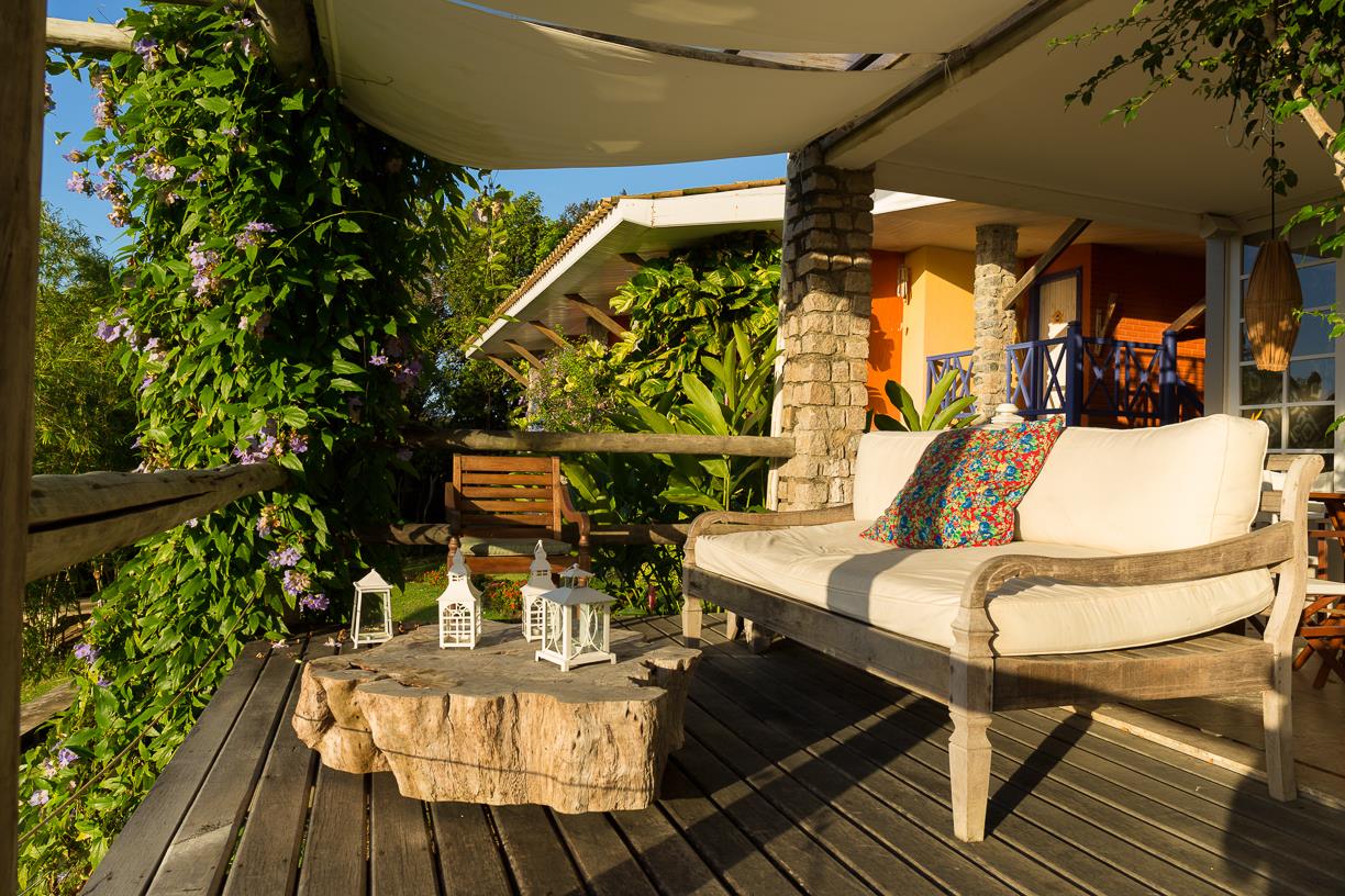 Um deck de madeira com um sofá e uma mesa em cima