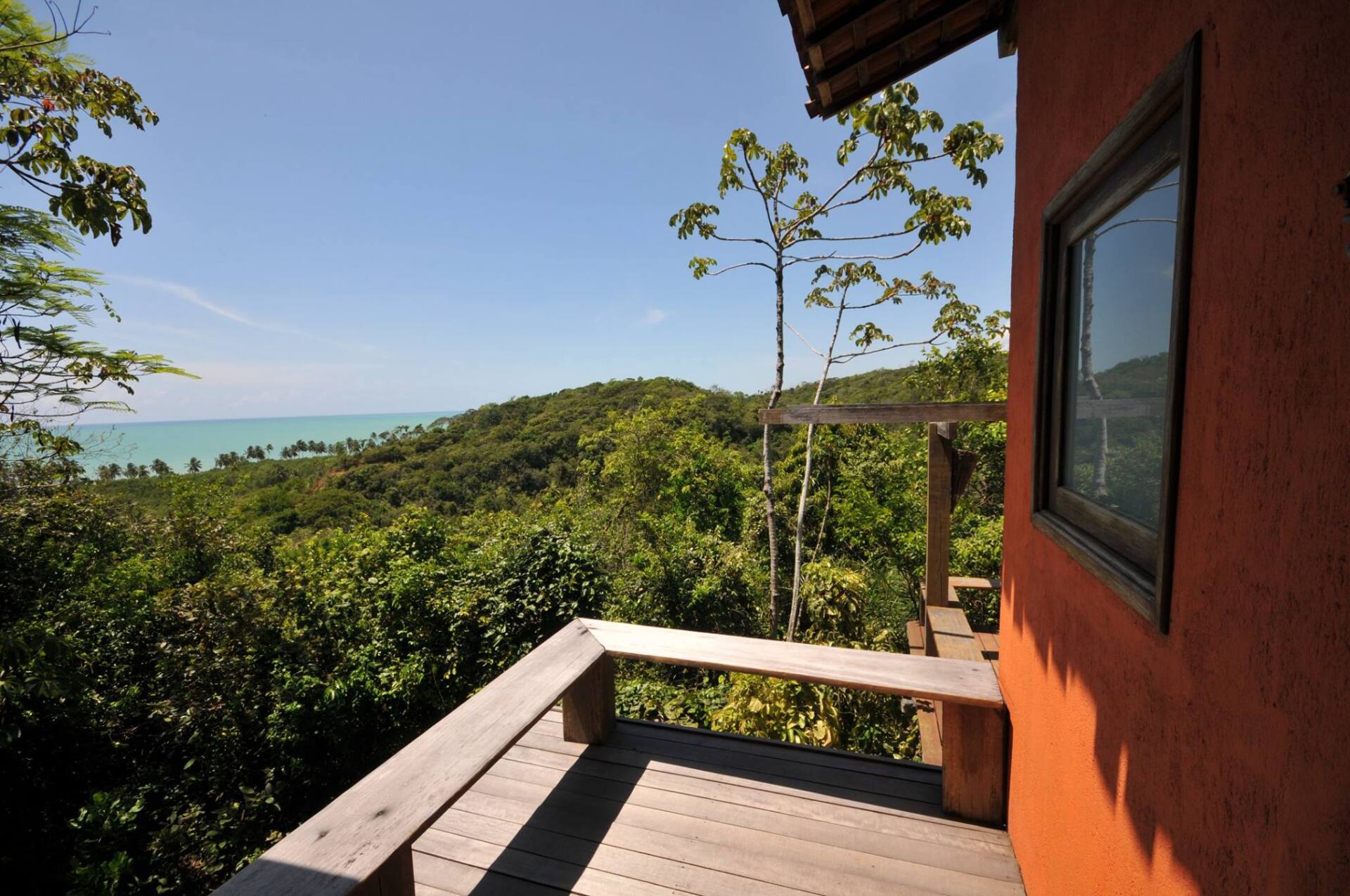 Uma varanda com vista para o oceano e as árvores