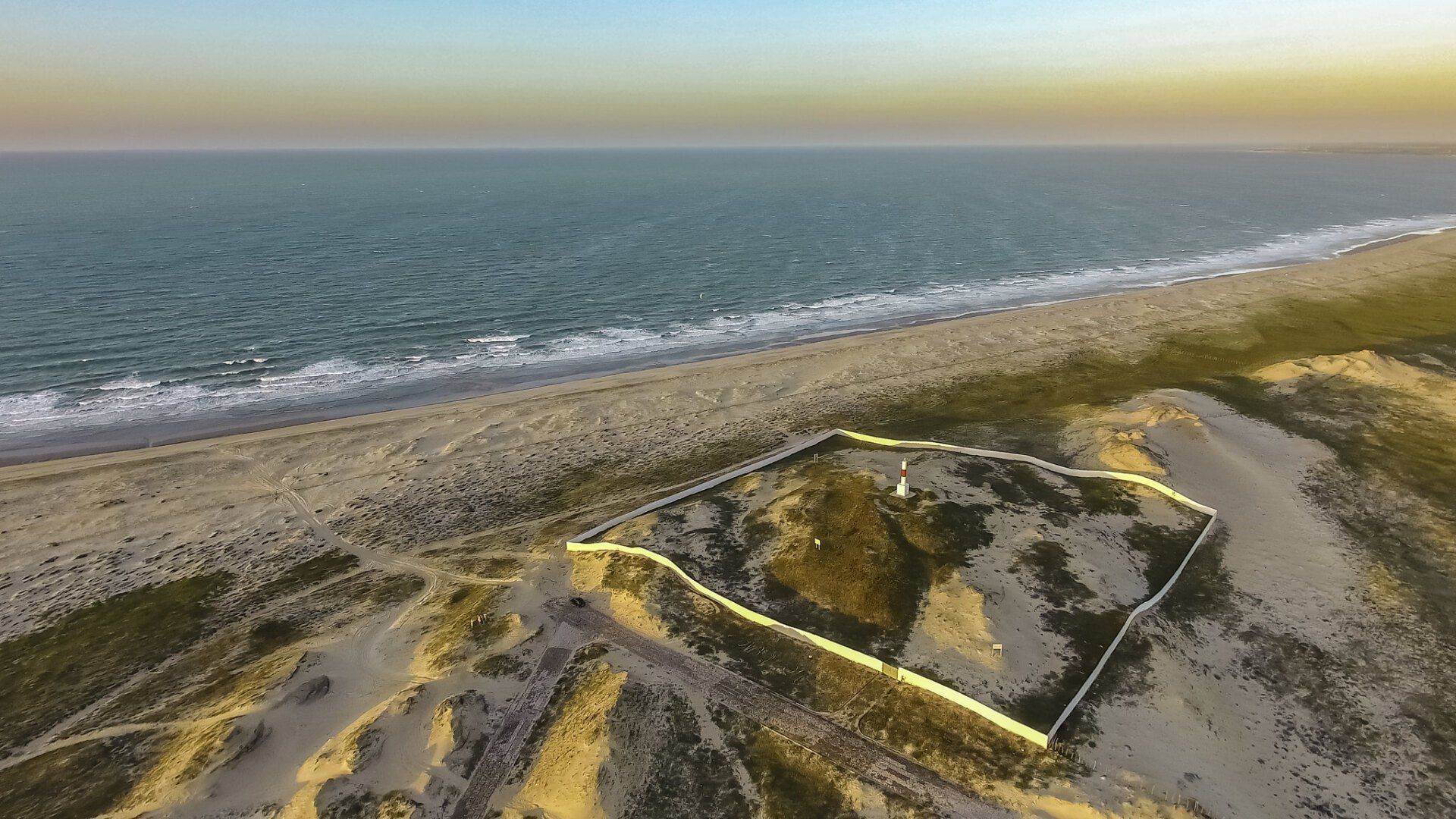 Uma vista aérea de uma praia de areia próxima ao oceano.