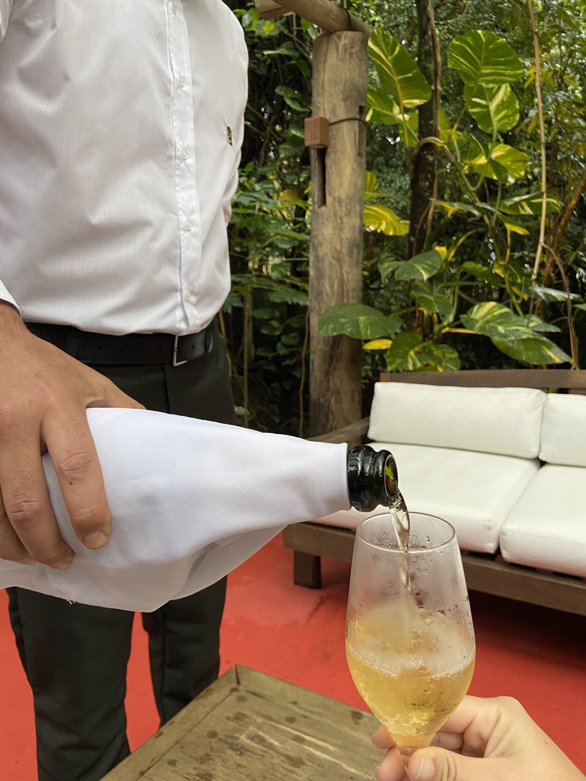 Um homem está servindo uma taça de vinho de uma garrafa