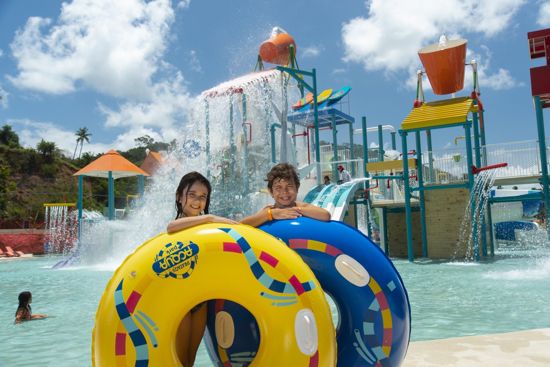 Duas crianças estão sentadas em boias em um parque aquático.