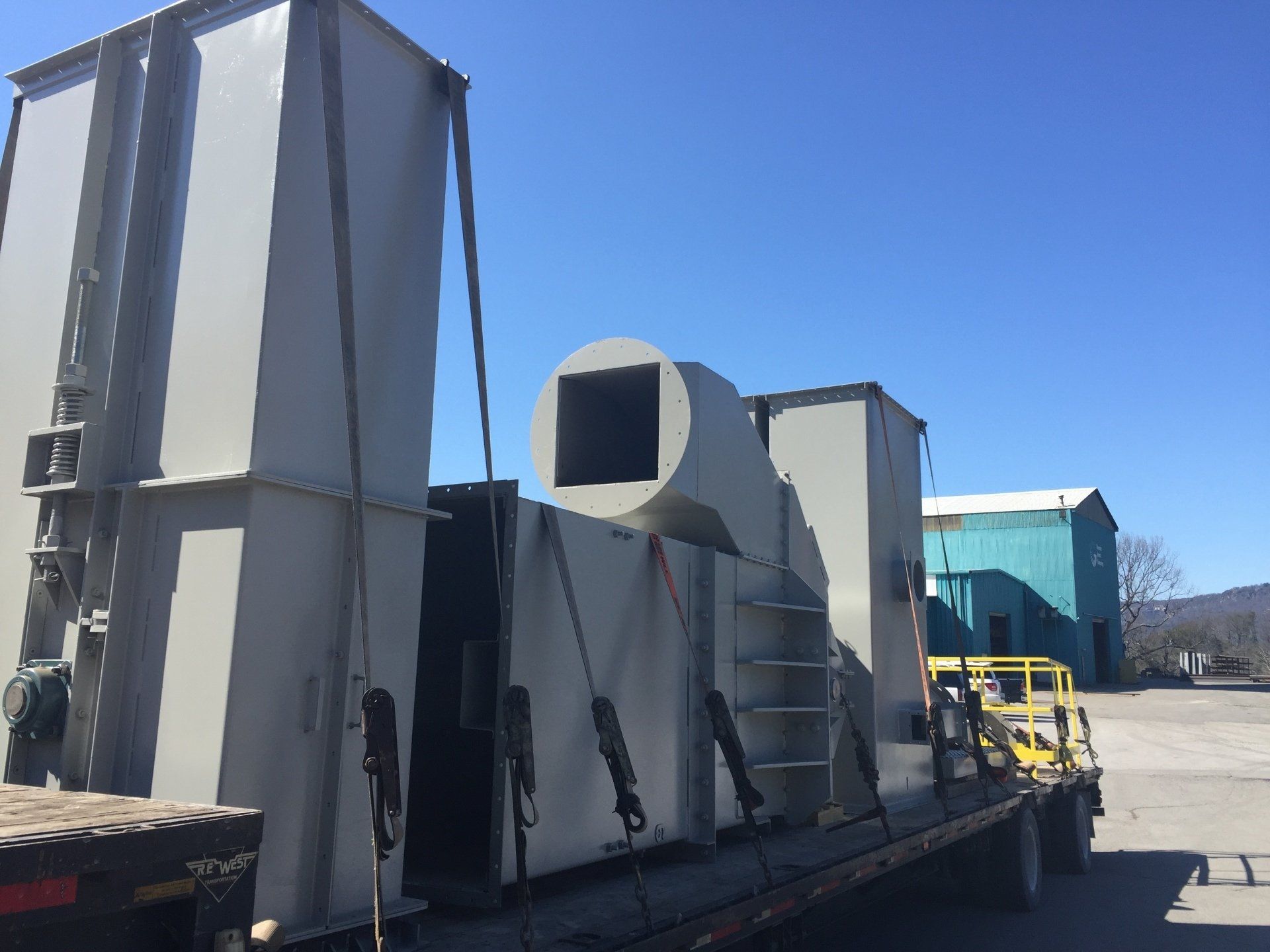 A large piece of metal is being loaded on a semi truck