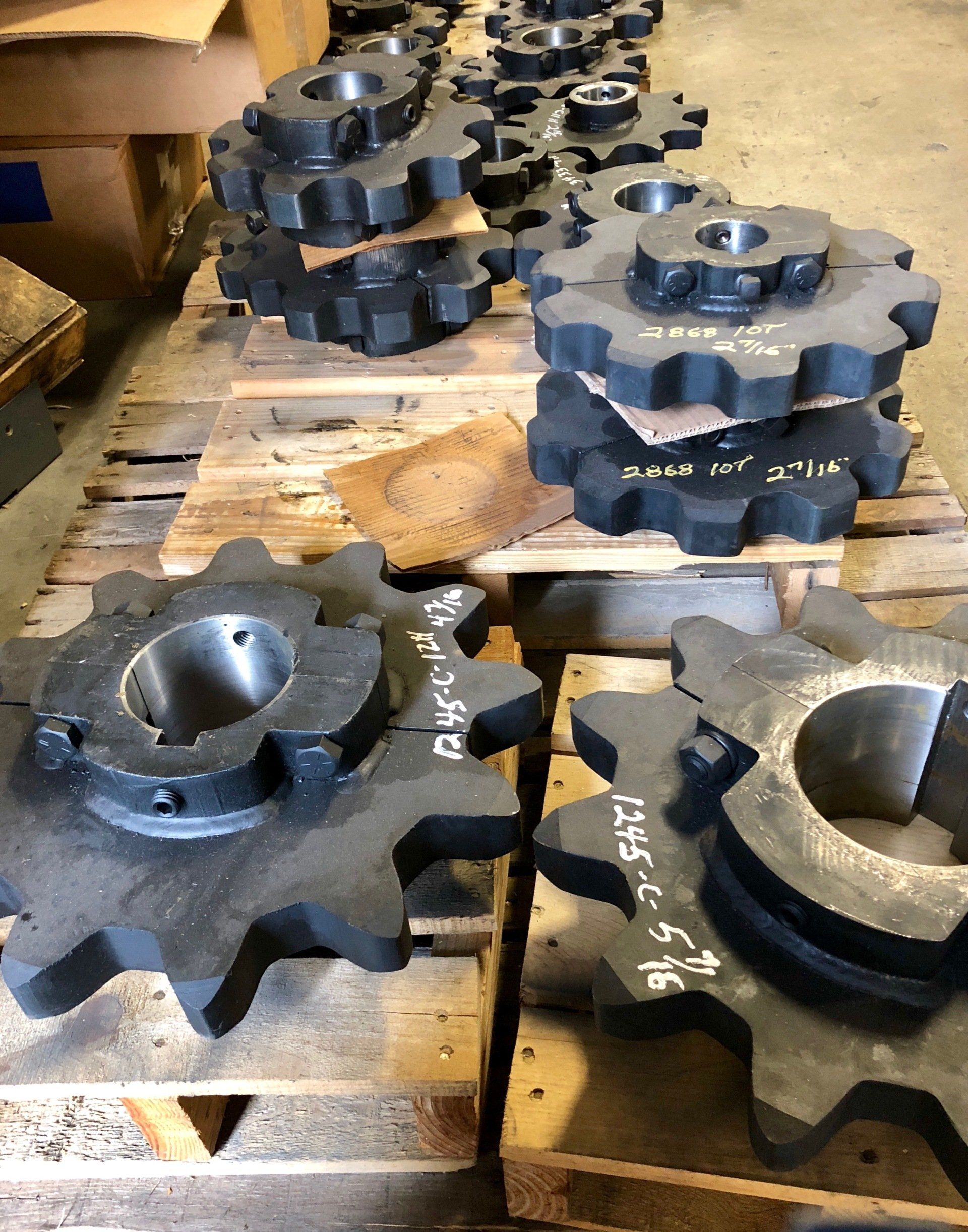 A bunch of gears are stacked on top of each other on wooden pallets.