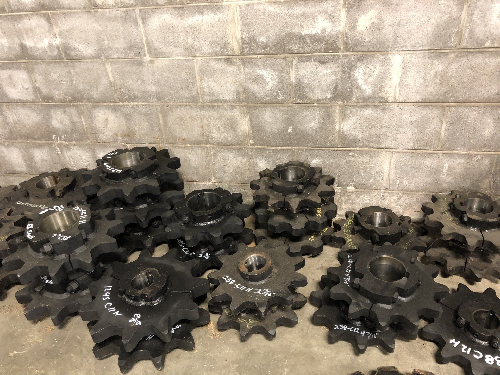 A bunch of gears are sitting in front of a brick wall.
