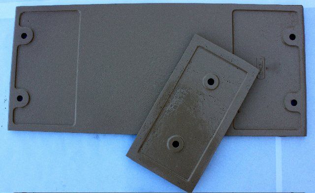 Two pieces of brown plastic with holes in them on a white surface