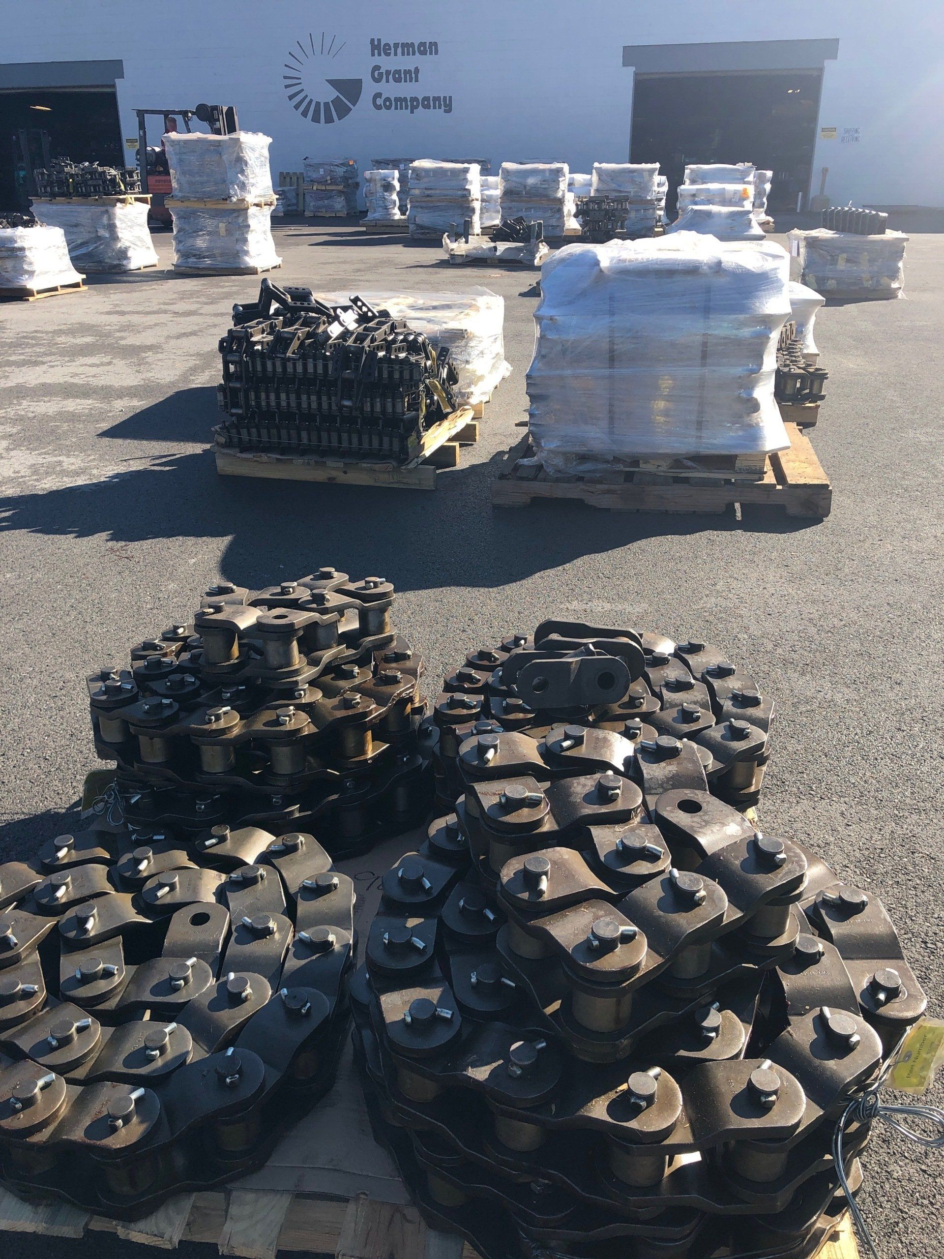 A bunch of chains are sitting on a pallet in front of a building that says horse drawn carriage