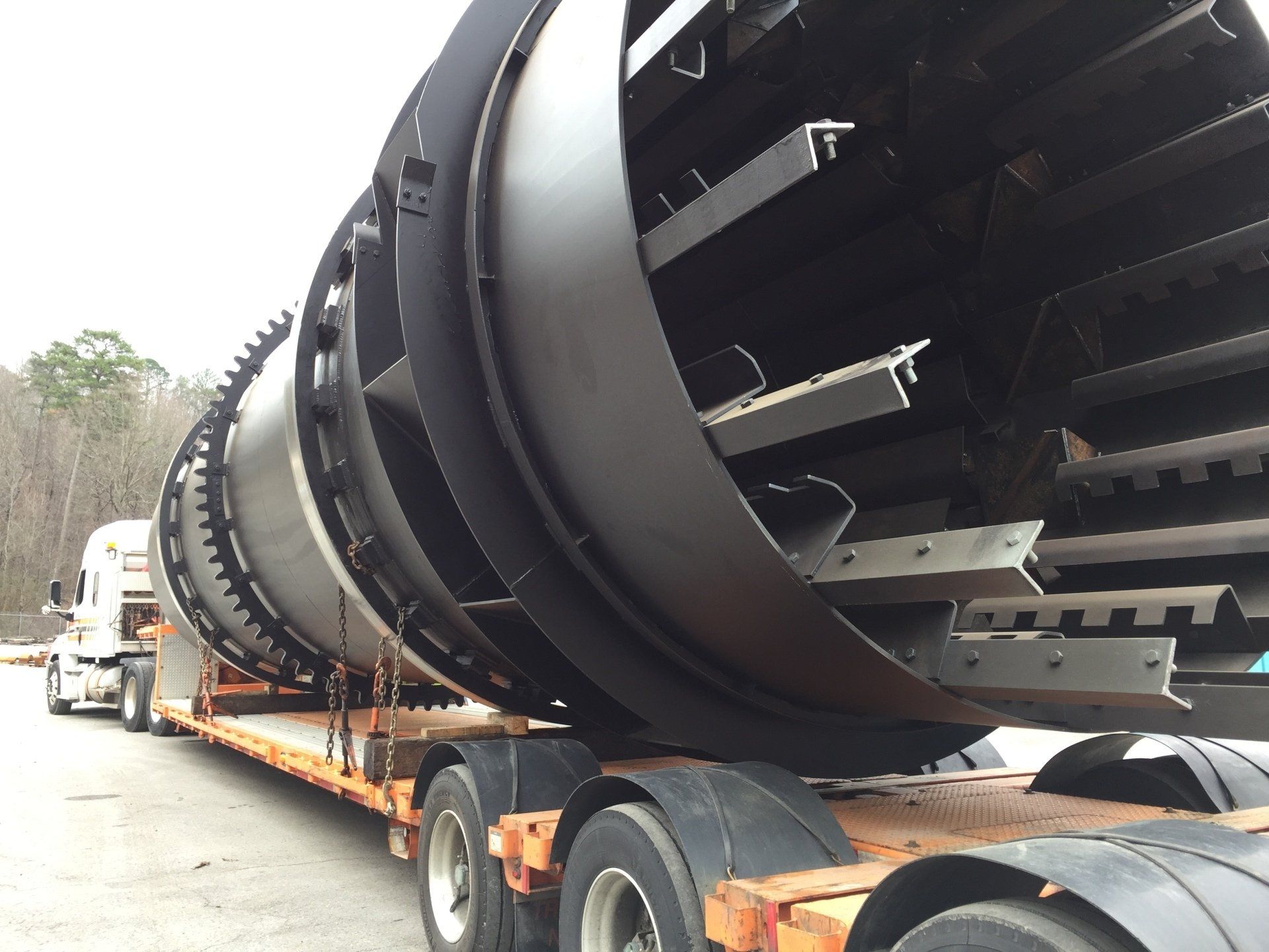 A large black object is being transported on a semi truck