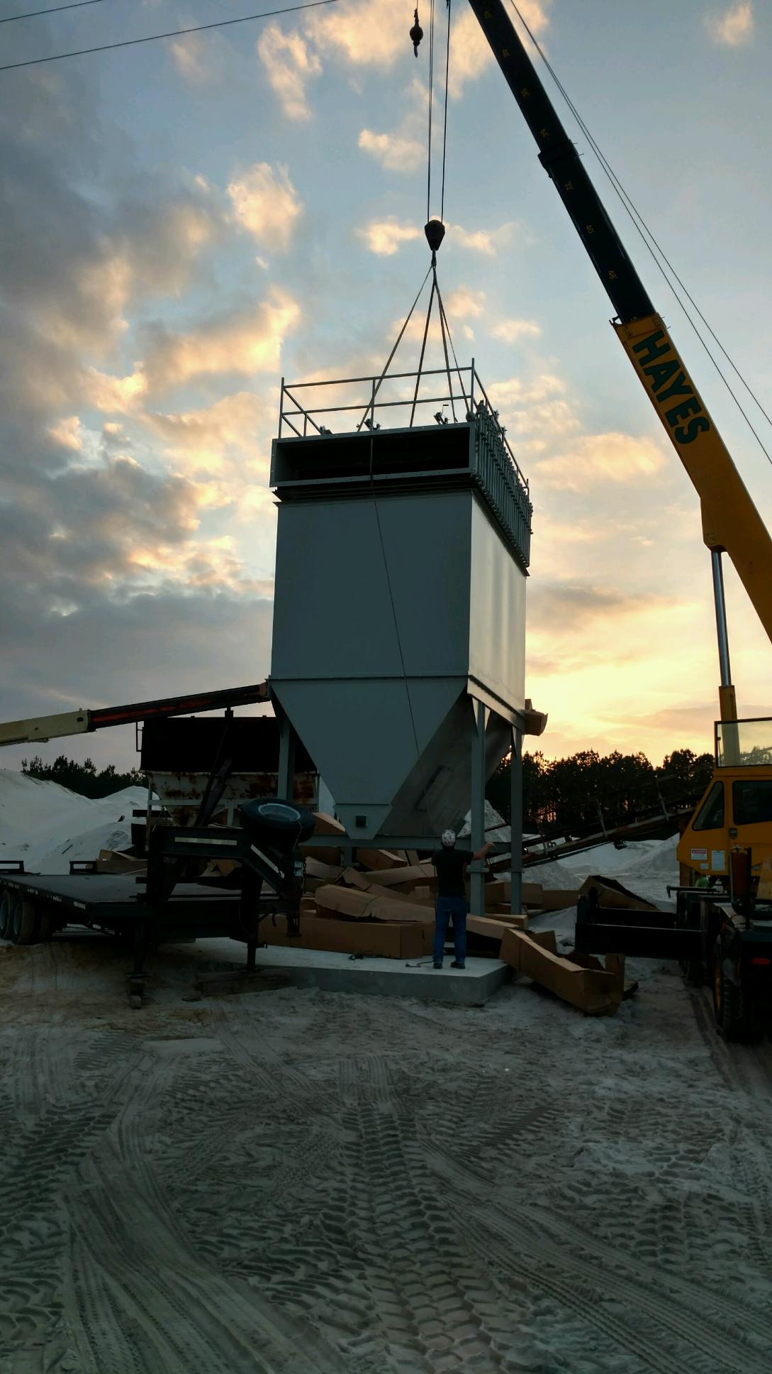 A crane is lifting a large structure in the air.