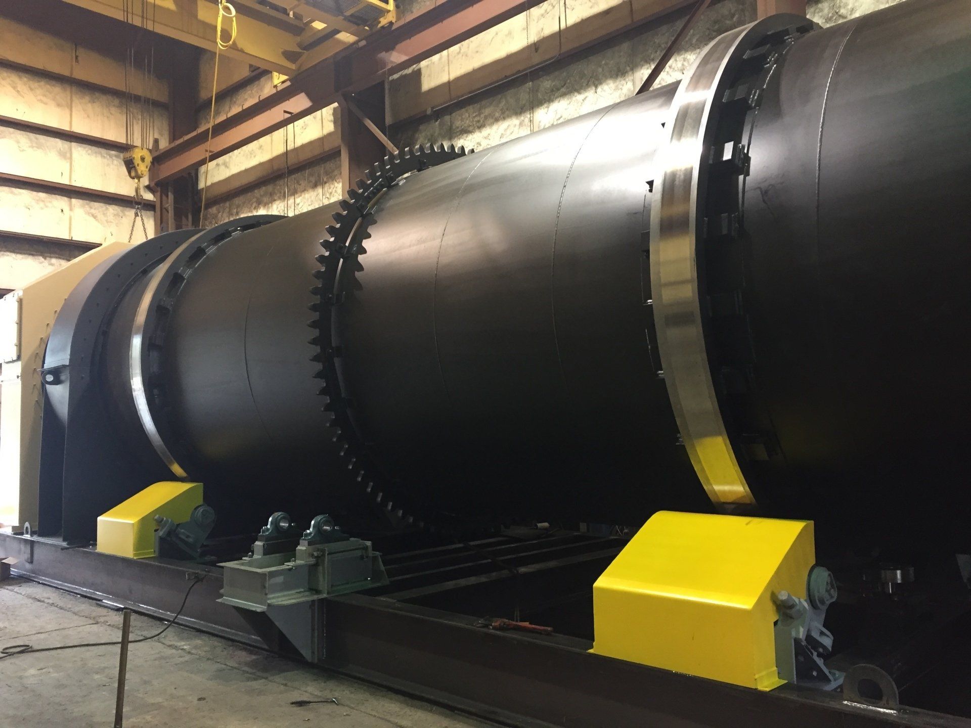 A large black pipe is sitting in a warehouse.