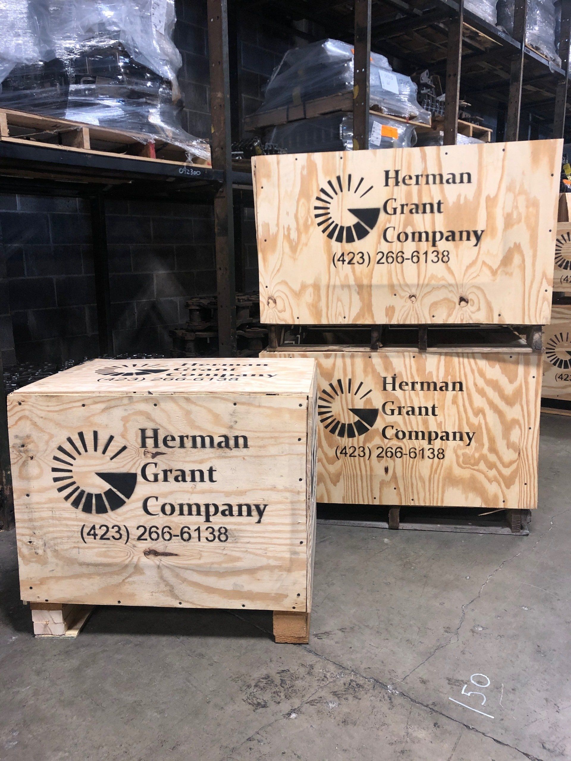 Two wooden crates are stacked on top of each other in a warehouse.