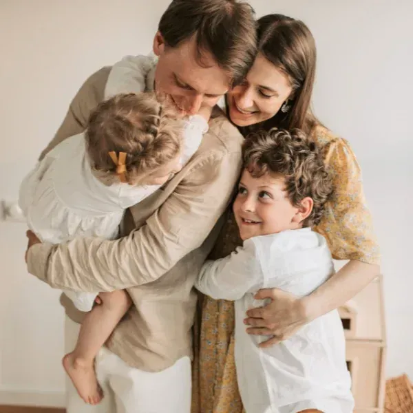 A man is holding a baby and a woman is holding a child.