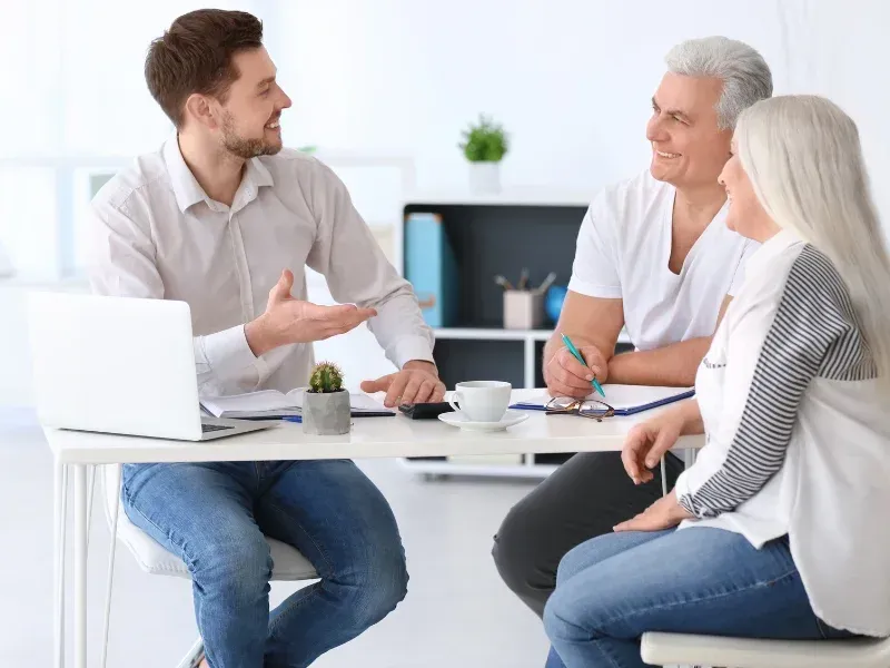 An image of an older couple discussing life insurance and final expense insurance coverage options with an agent.