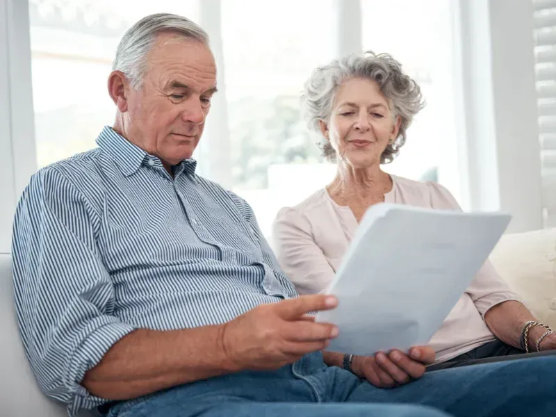 An image showing an elderly couple reviewing life insurance policy documents together.