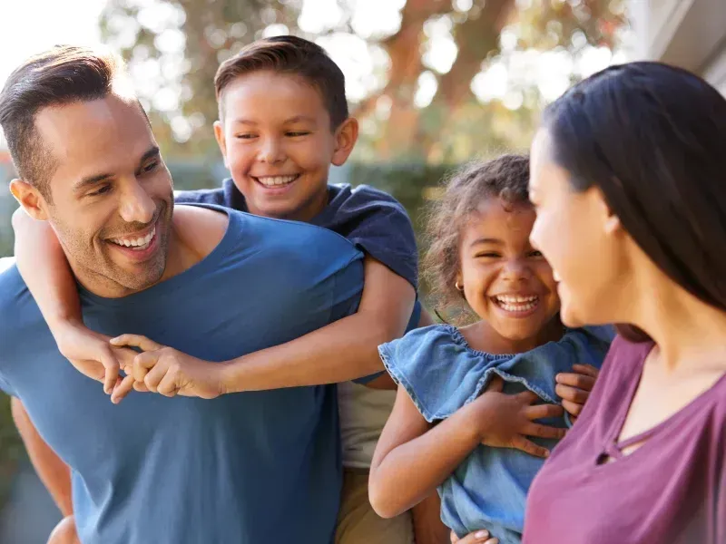 An image showing a happy family with parents and children smiling together.