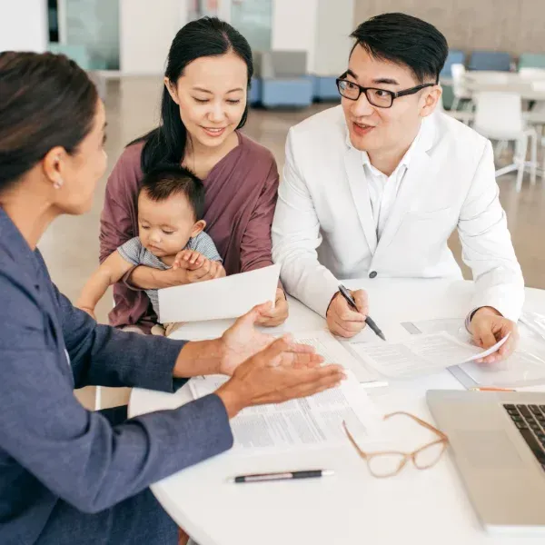 An image of an insurance agent discussing whole life insurance with a family.