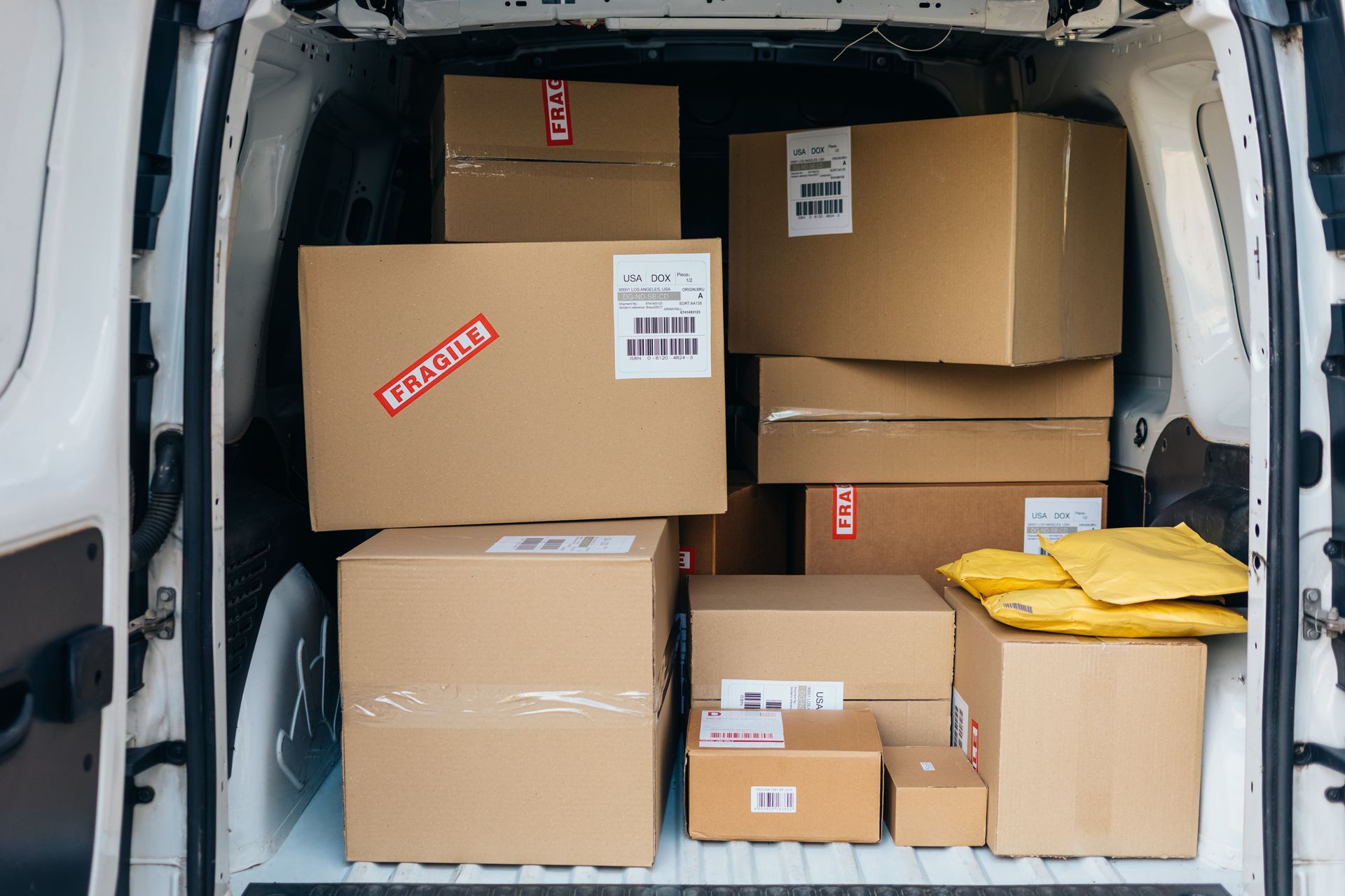 Boxes and packages inside a white delivery van, ready for shipping.