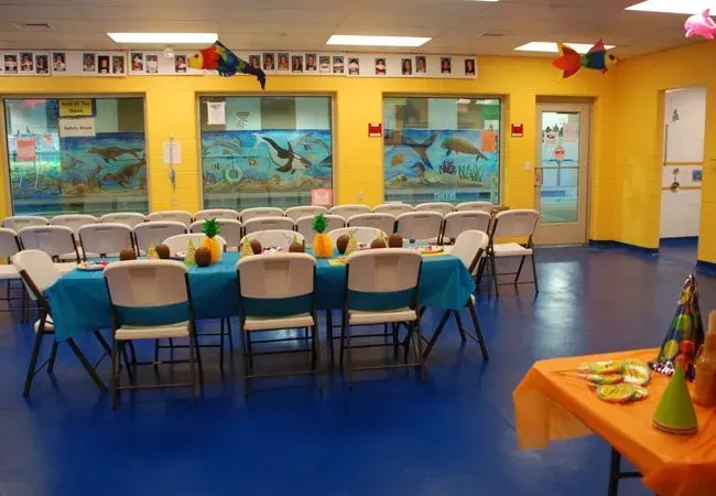 A large room with tables and chairs set up for a party