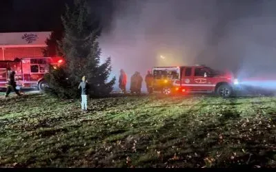 A group of people are standing in front of a fire truck.