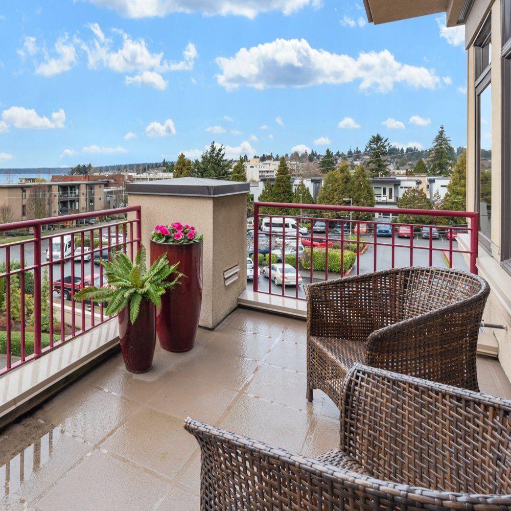 A balcony with wicker chairs and potted plants