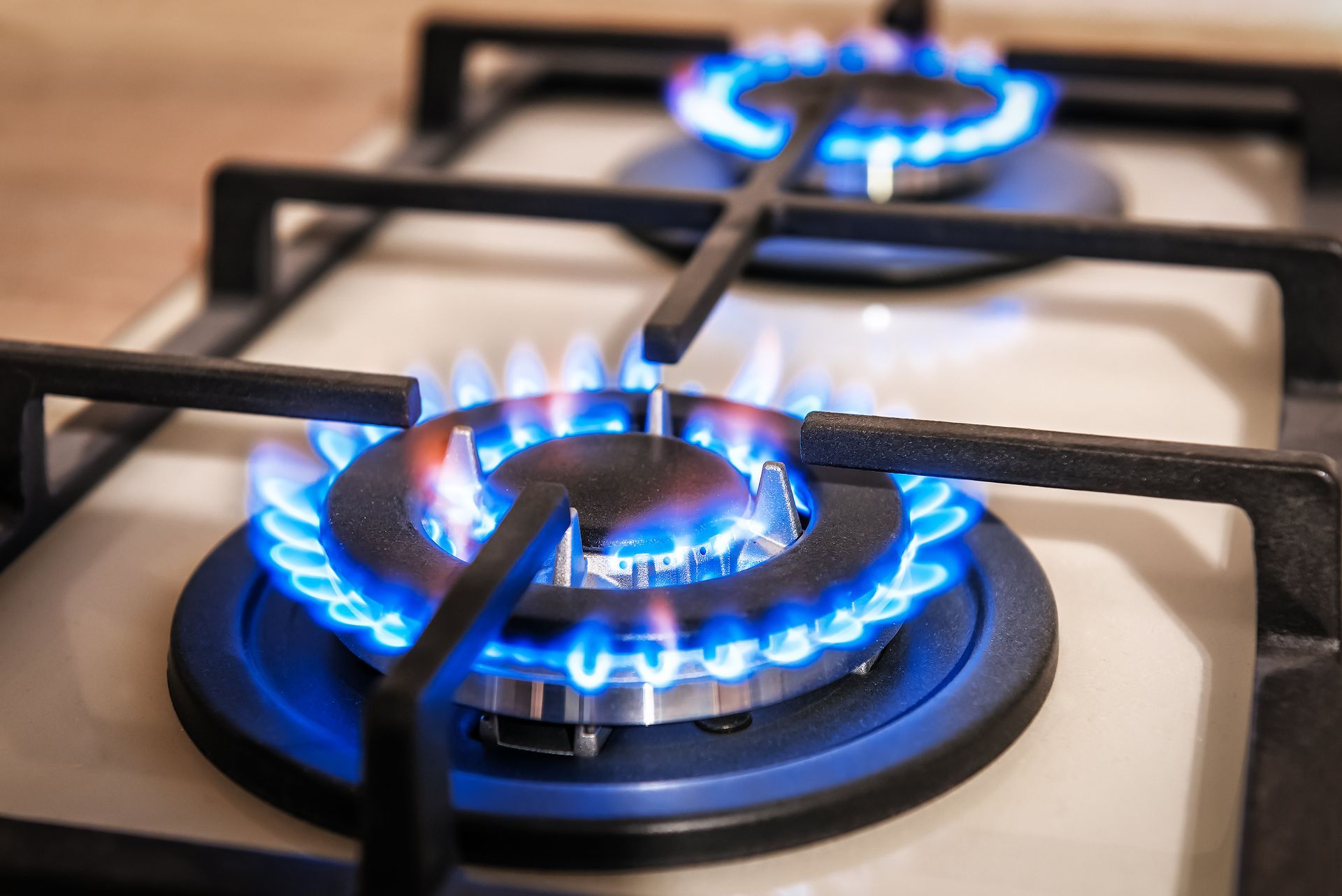 A close up of two gas burners on a stove.