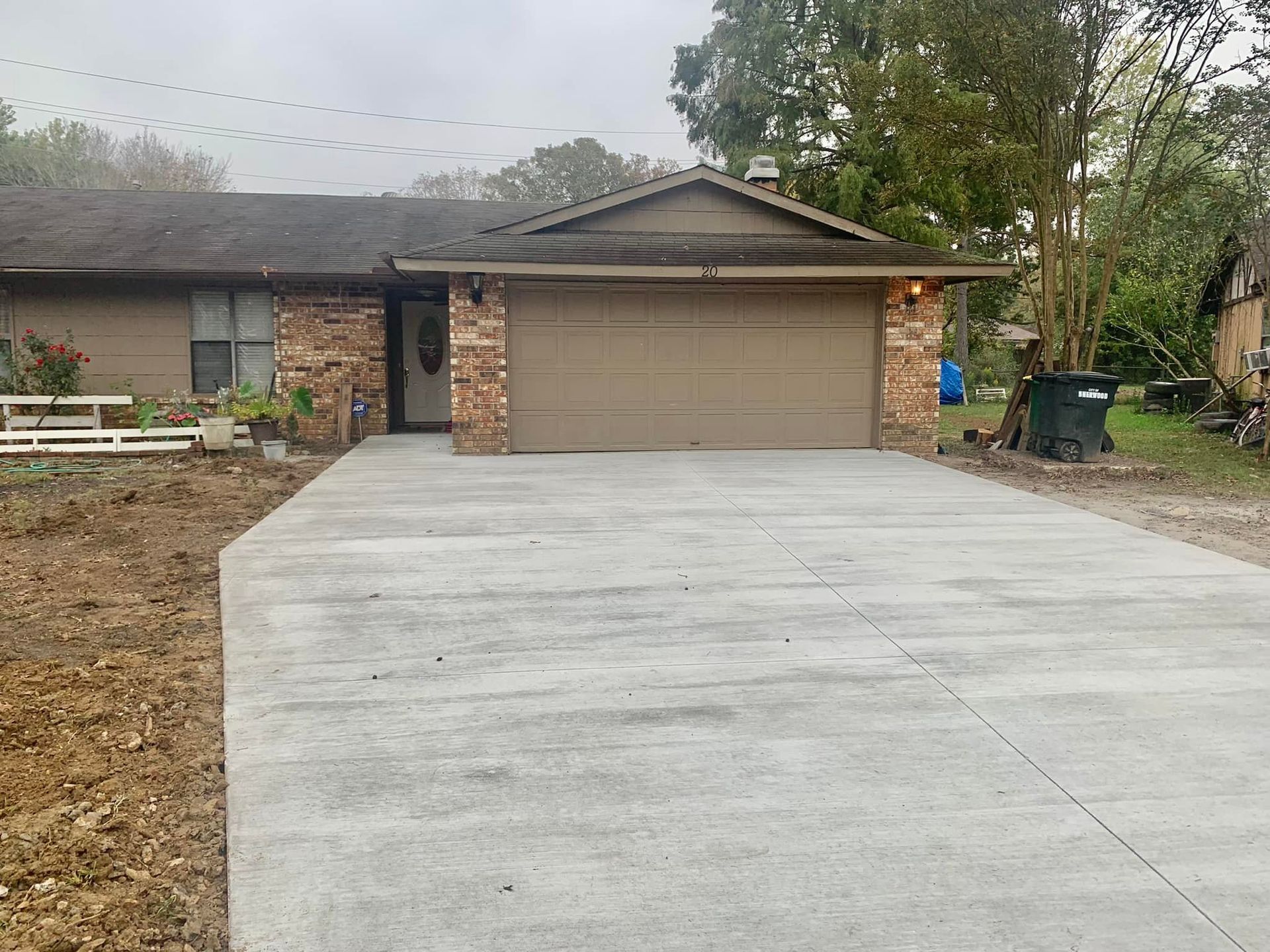 A house with a garage and a concrete driveway in front of it.