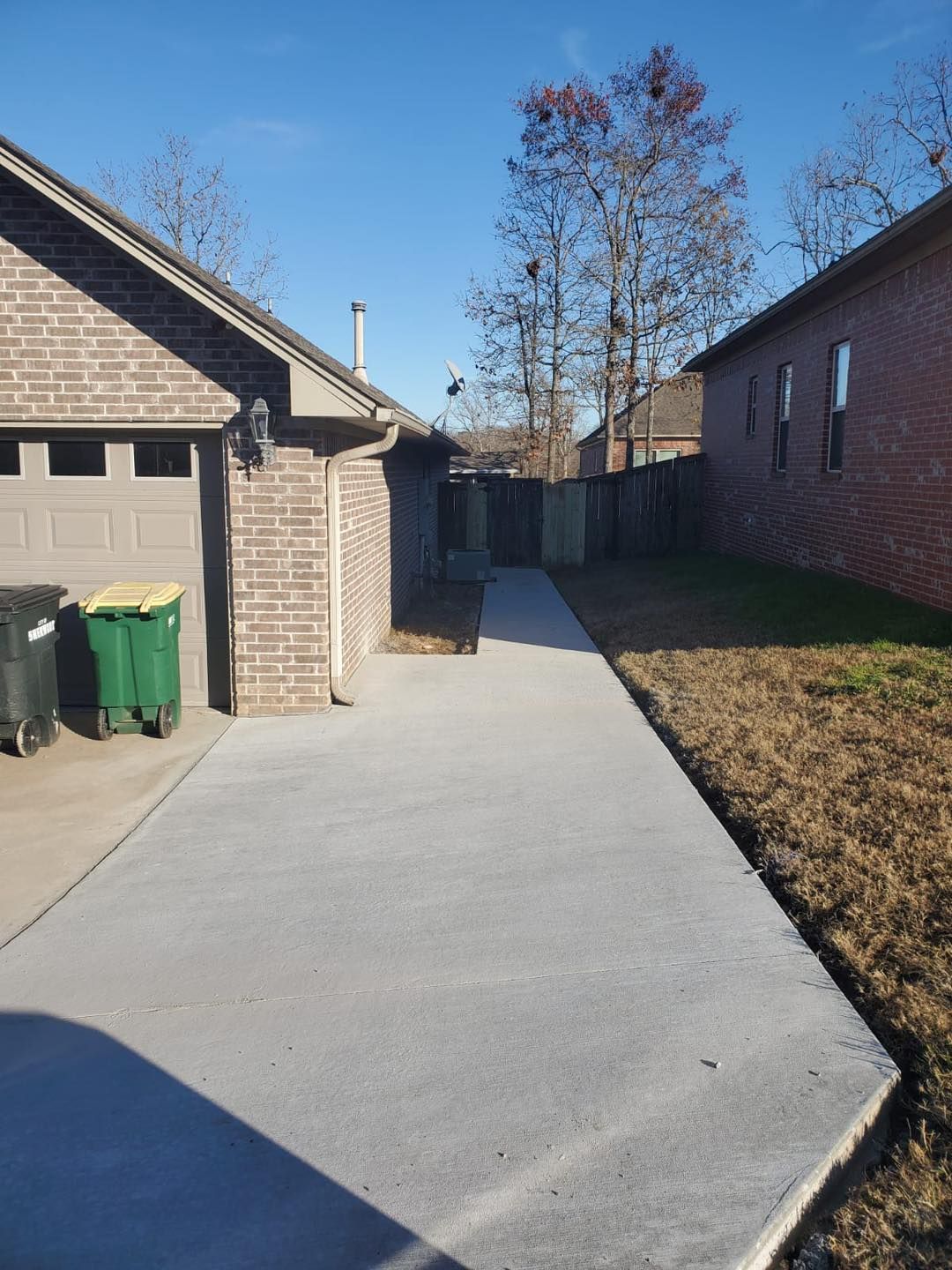 A brick house with a concrete walkway leading to it