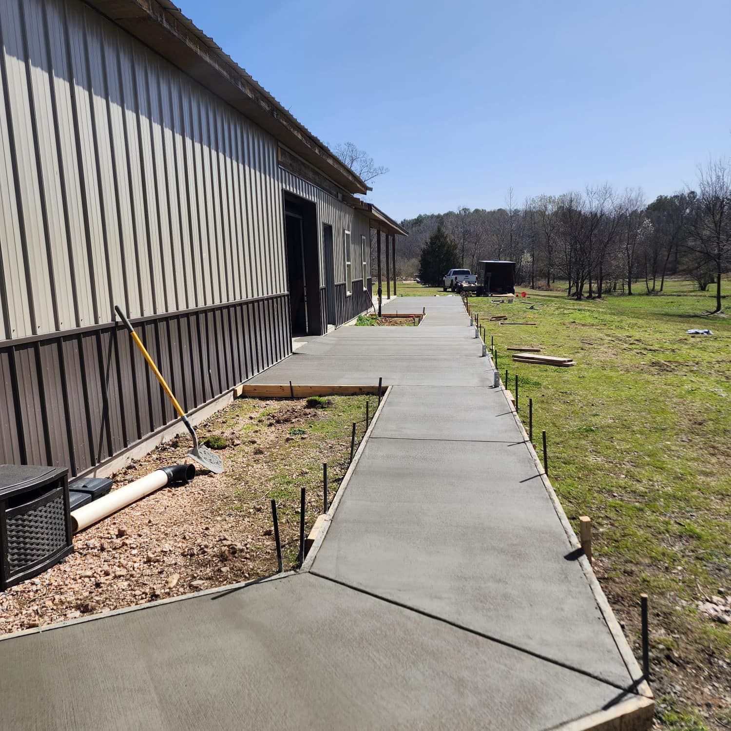 A concrete walkway is being built in front of a building