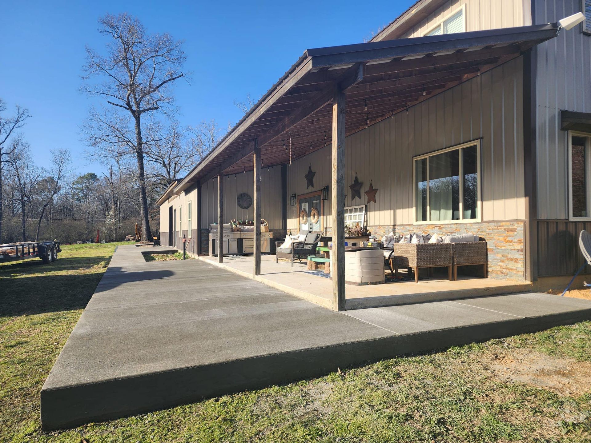 A large house with a covered porch and a concrete walkway leading to it.