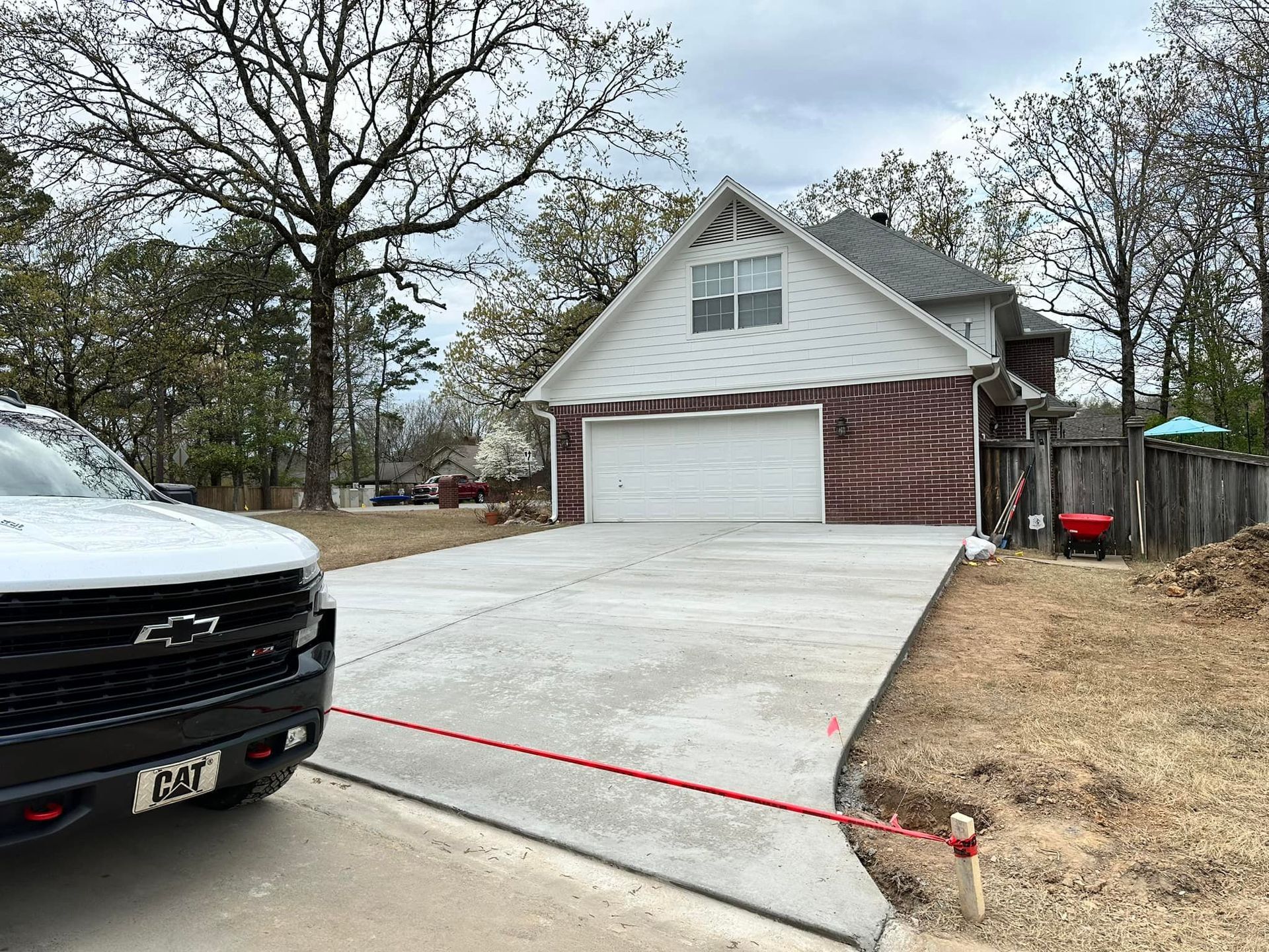 A truck is parked in front of a house with a concrete driveway.