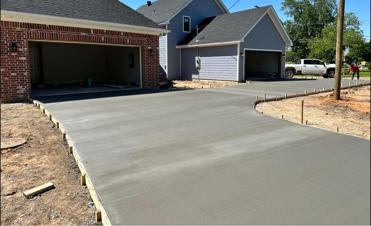 A concrete driveway is being built in front of a house.
