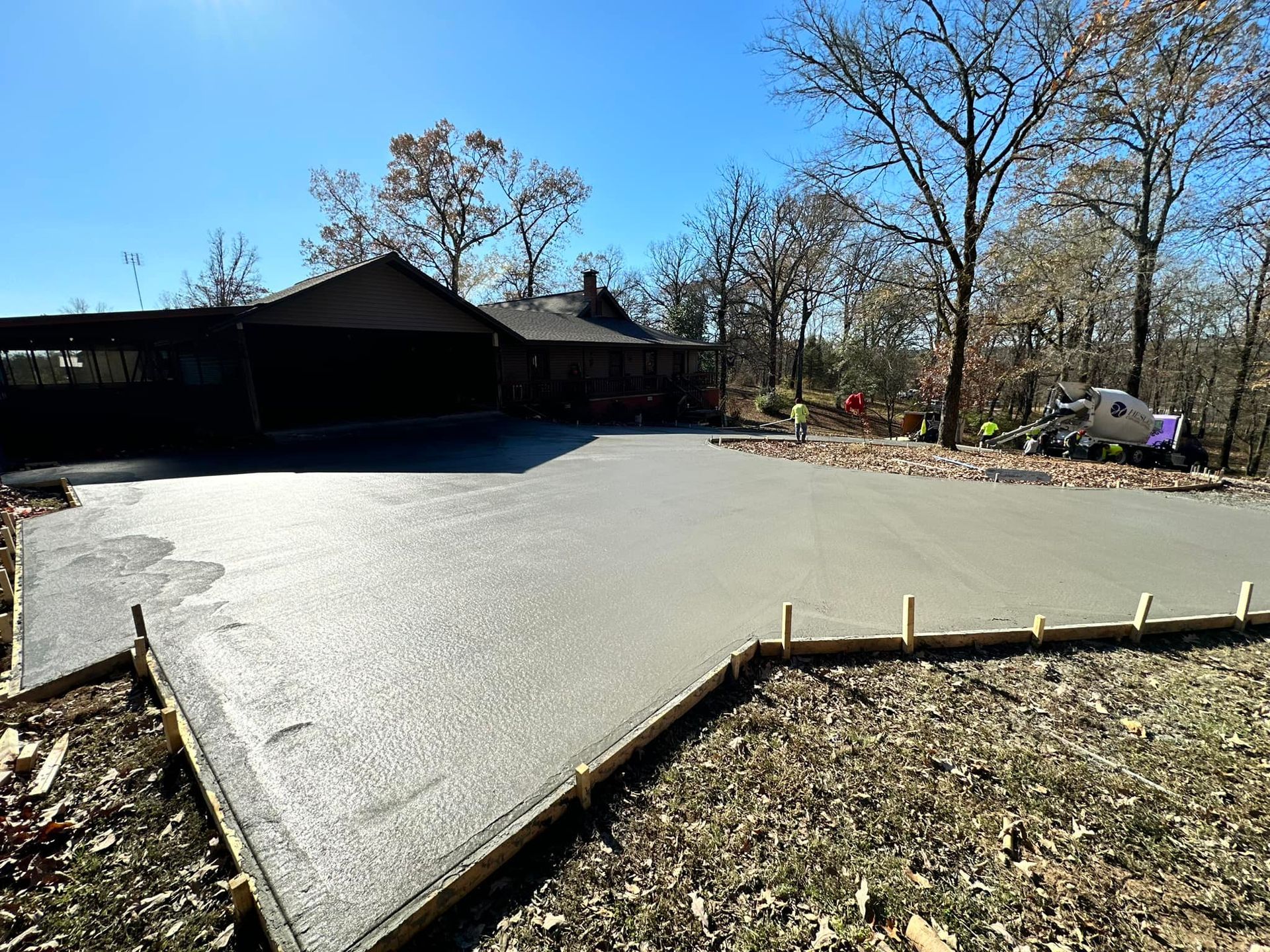 A concrete driveway is being built in front of a house.