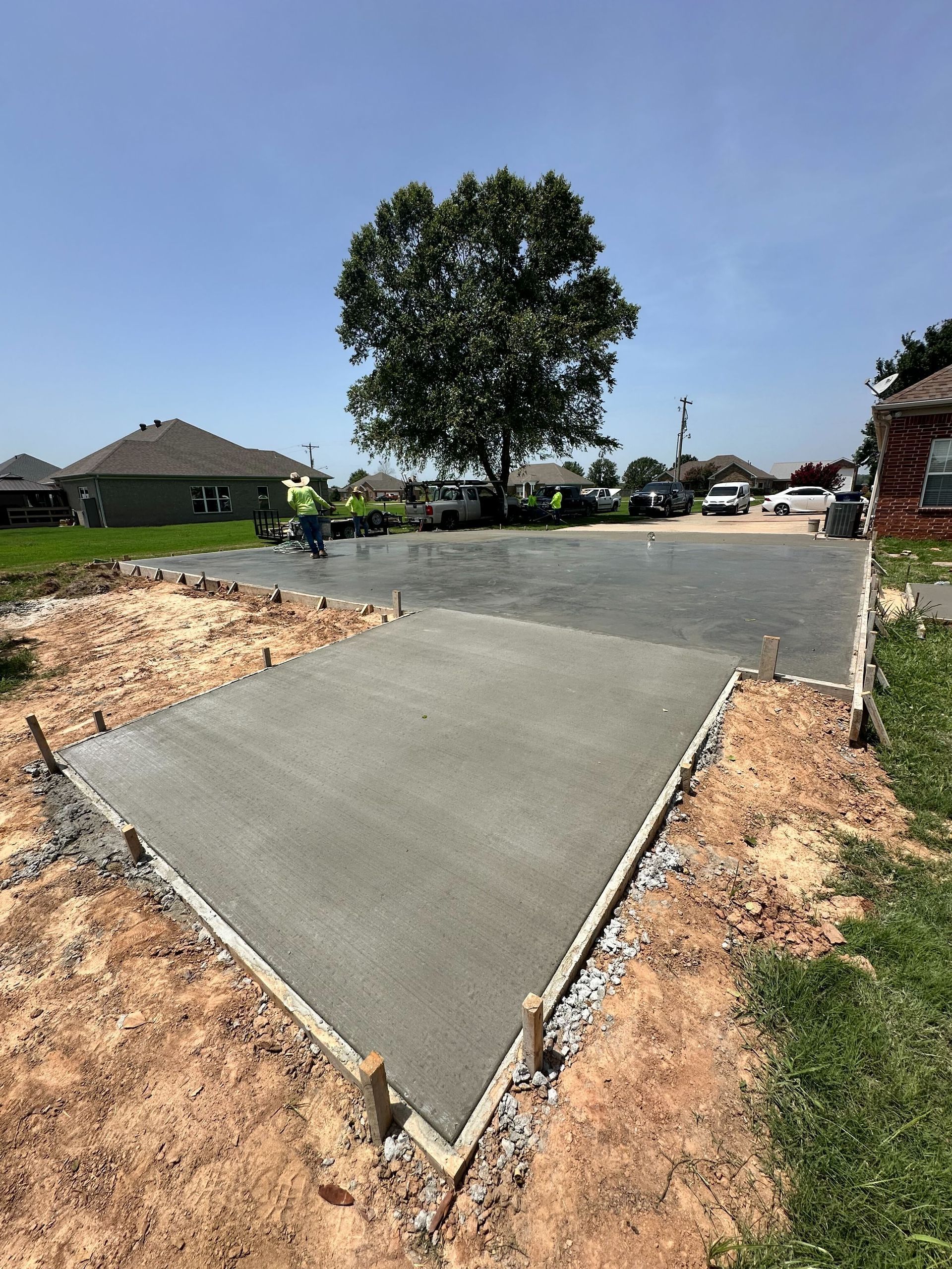 A concrete driveway is being built in a residential area.