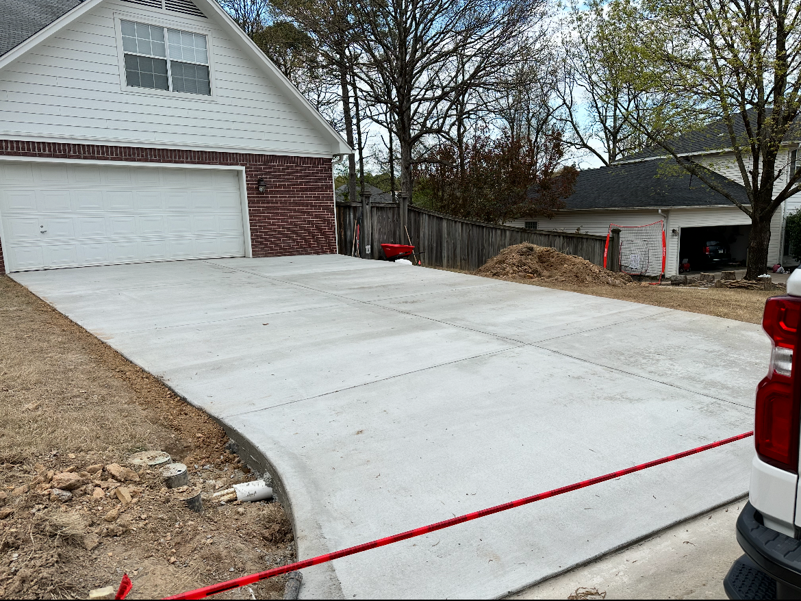 A concrete driveway is being built in front of a house.