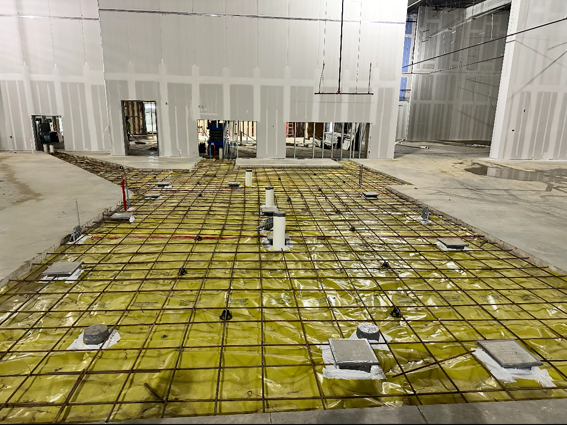 A concrete floor is being built in a building.