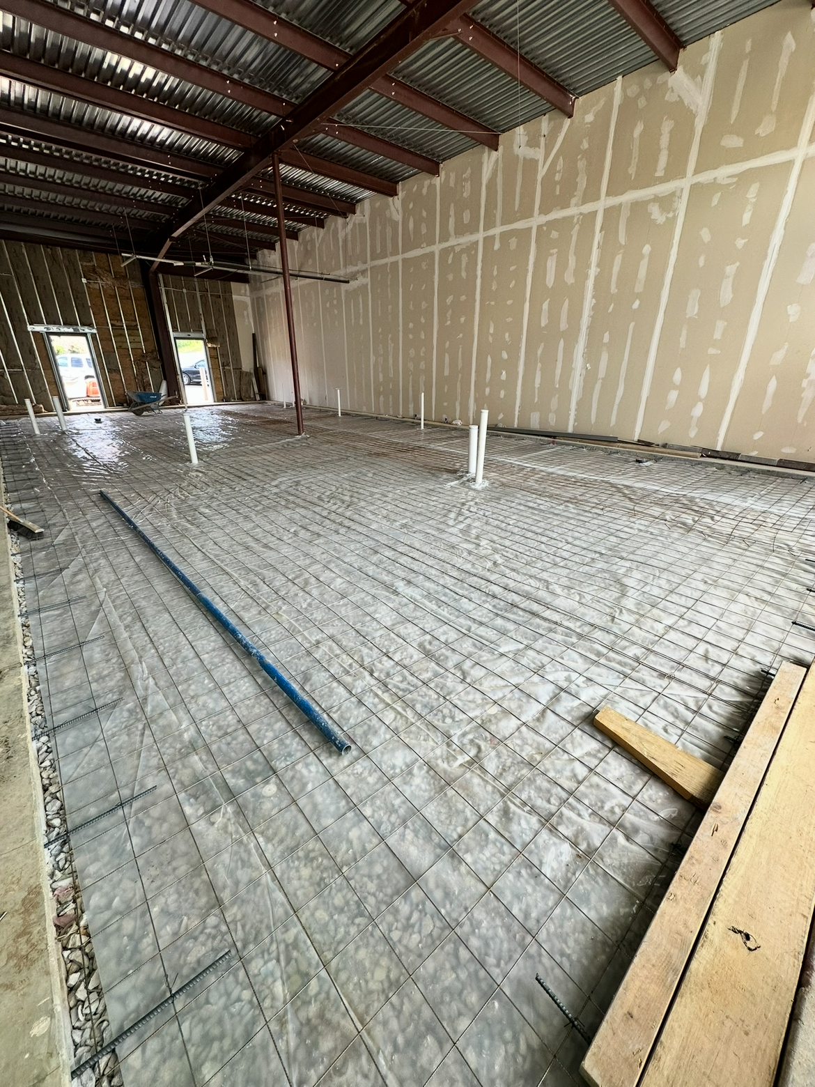 A large empty room with a brick floor and a metal roof.