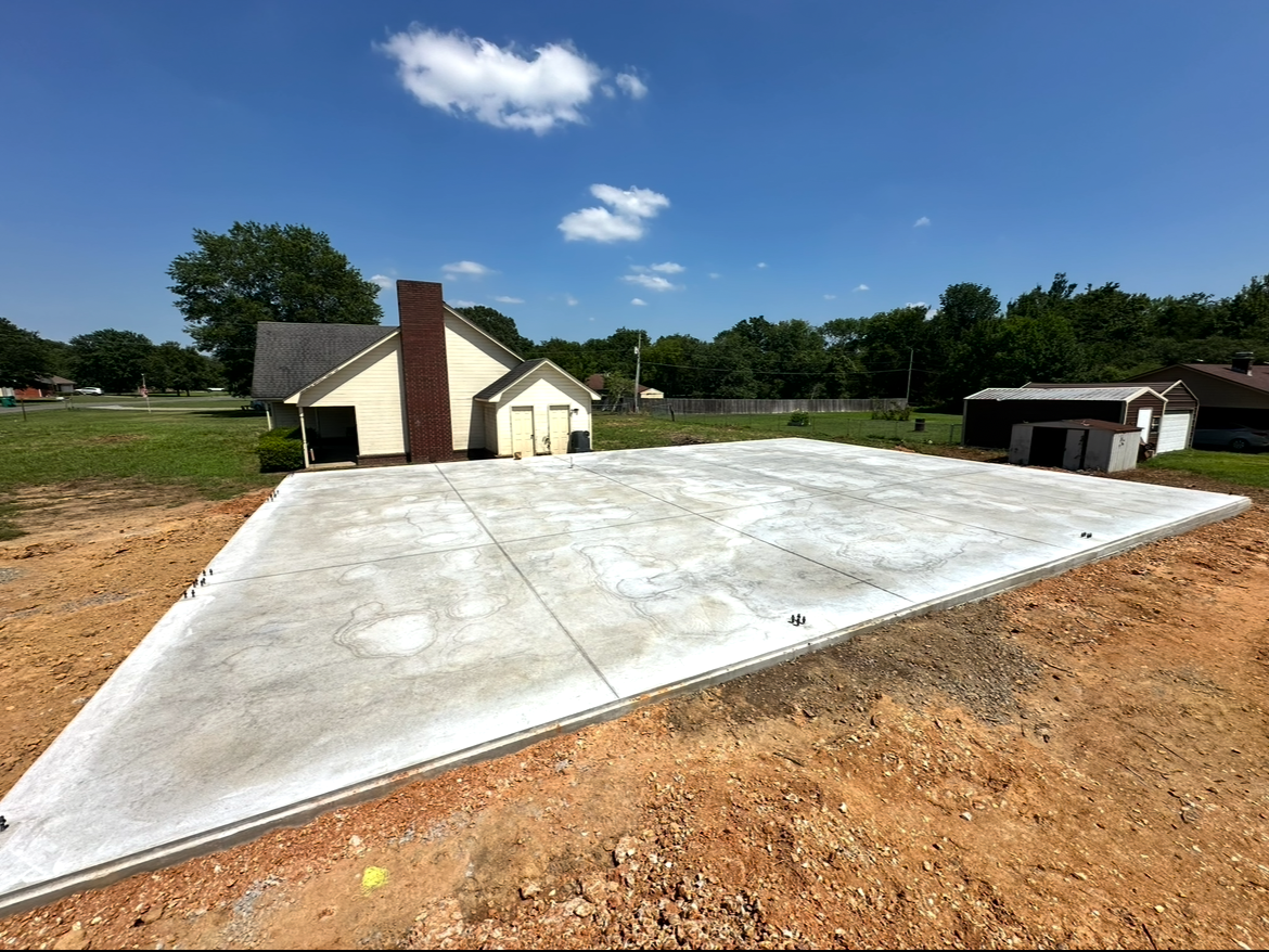 A concrete driveway is being built in front of a house.
