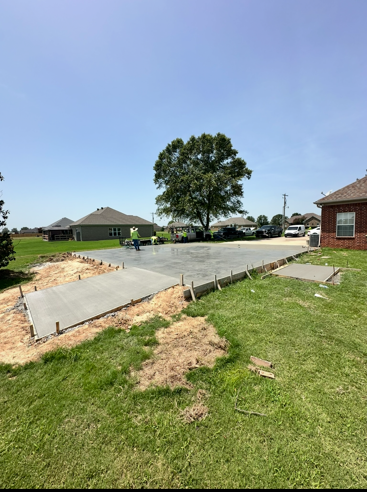 A concrete driveway is being built in front of a house.