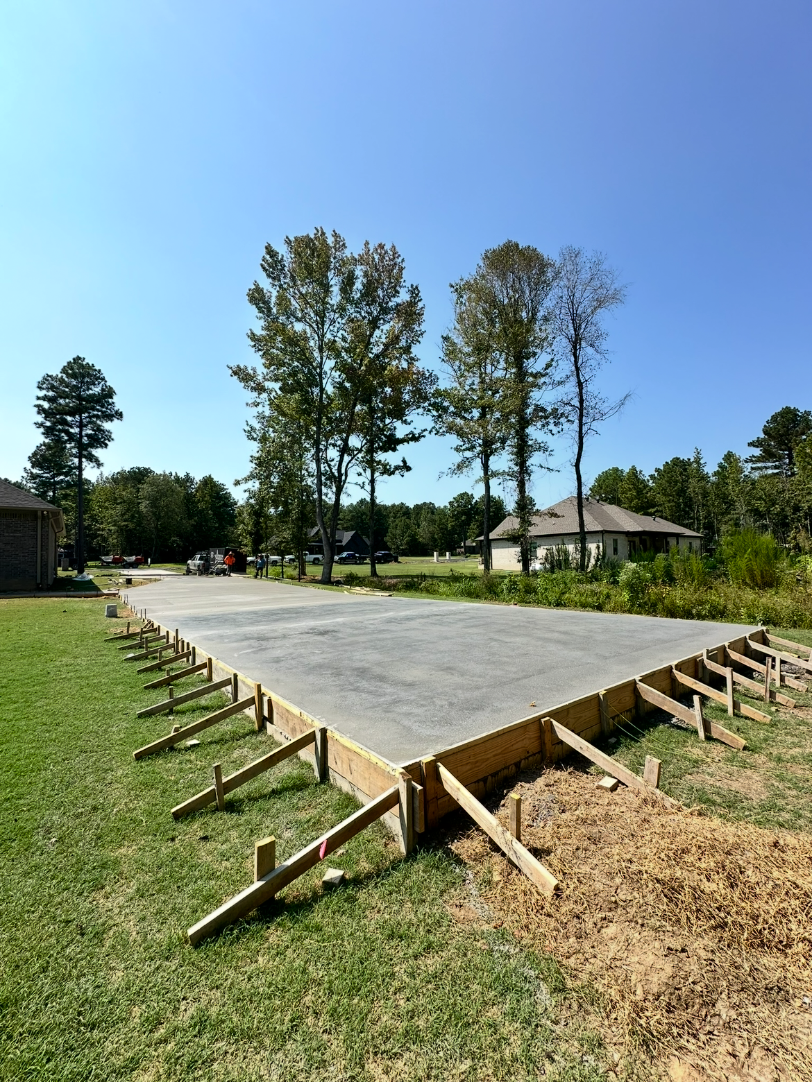 A large concrete slab is sitting in the middle of a grassy field.