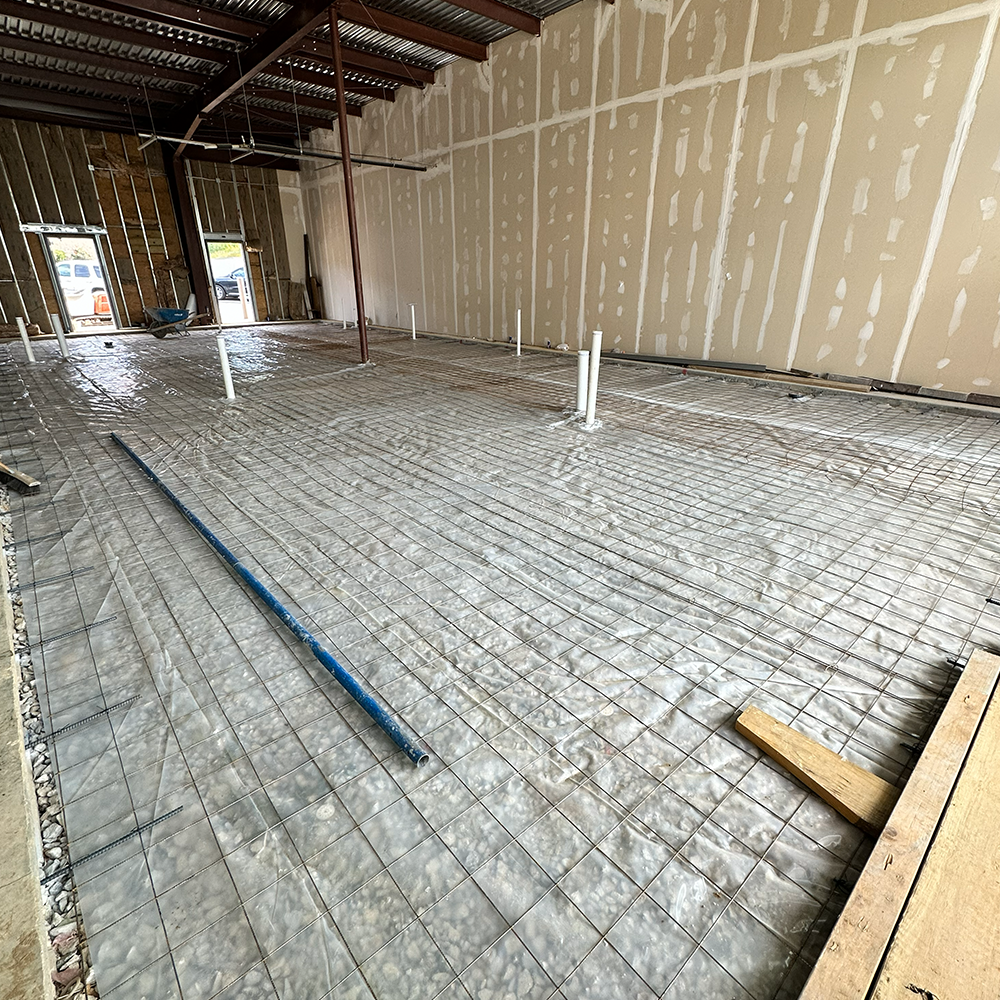 A house with a wooden fence and a concrete walkway leading to it