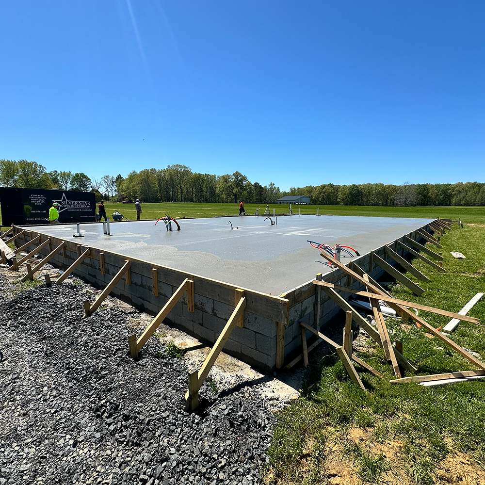 A house with a wooden fence and a concrete walkway leading to it