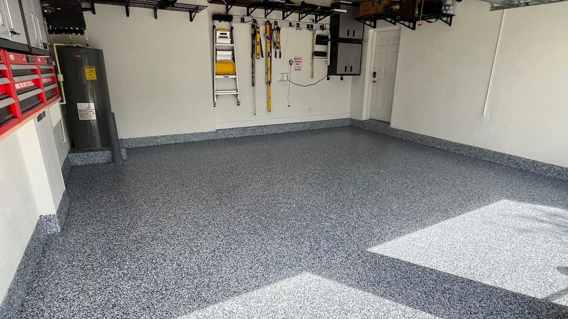 Finished epoxy garage floor coating with decorative flake finish inside residential garage in Arkans
