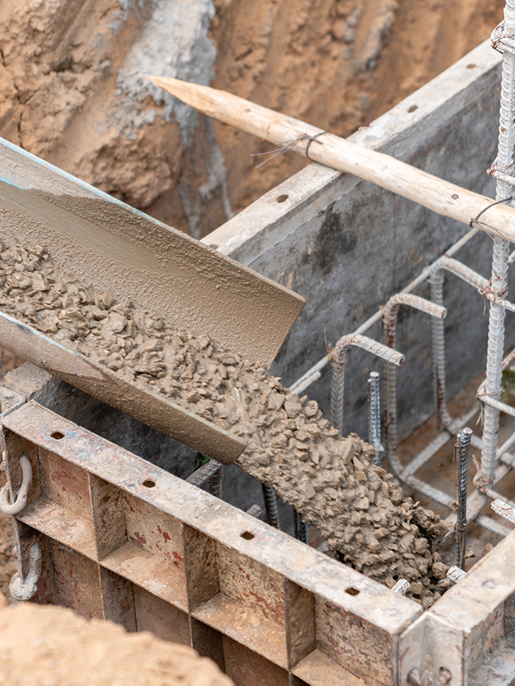 Concrete is being poured into a concrete foundation at a construction site.