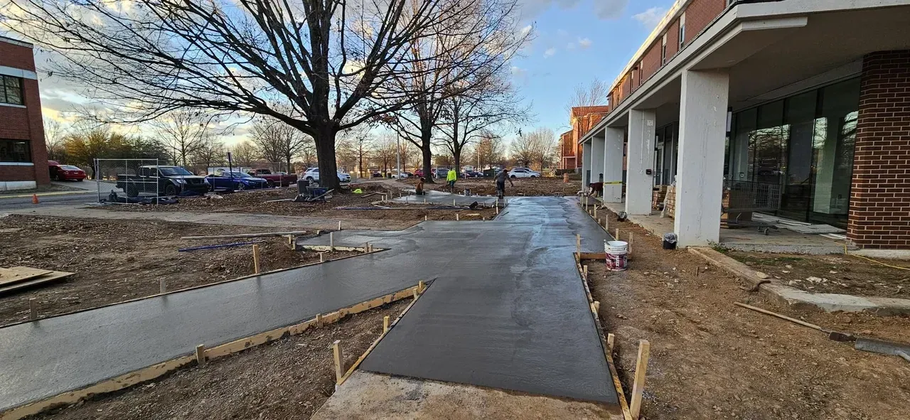 A concrete walkway is being built in front of a building.
