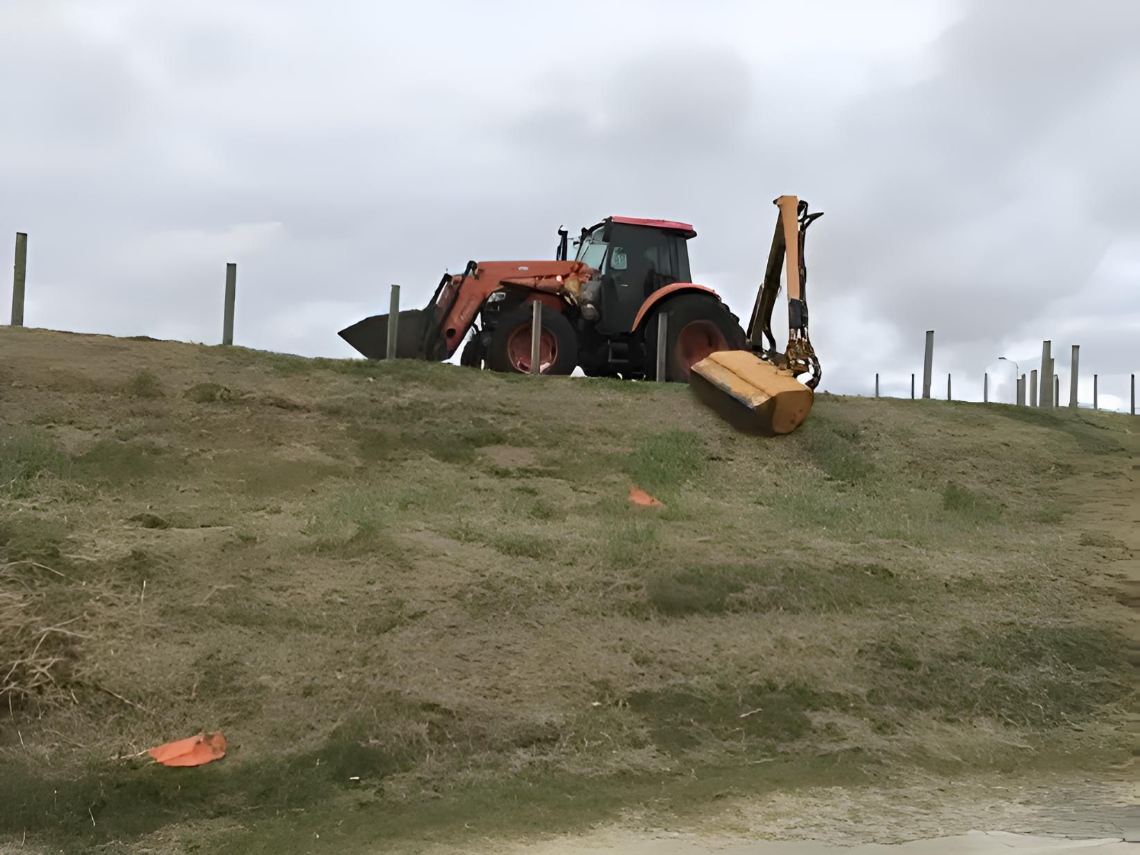 A Tractor Is Sitting On Top Of A Grassy Hill — Cane Country Slashing & Mowing In Marian, QLD
