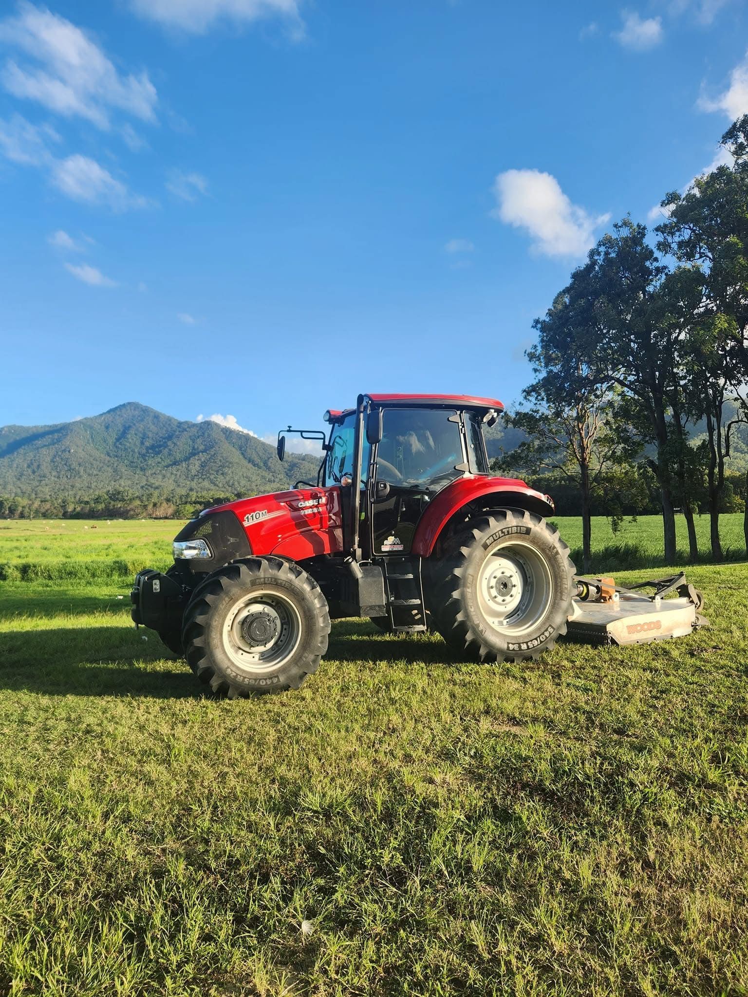 A Man Is Cutting Grass With A Lawn Mower In A Field — Cane Country Slashing & Mowing In Marian, QLD