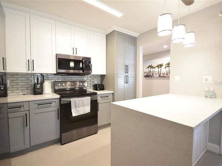 A kitchen with stainless steel appliances and white cabinets