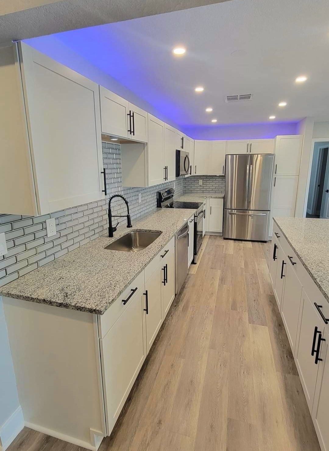 A kitchen with stainless steel appliances and granite counter tops.