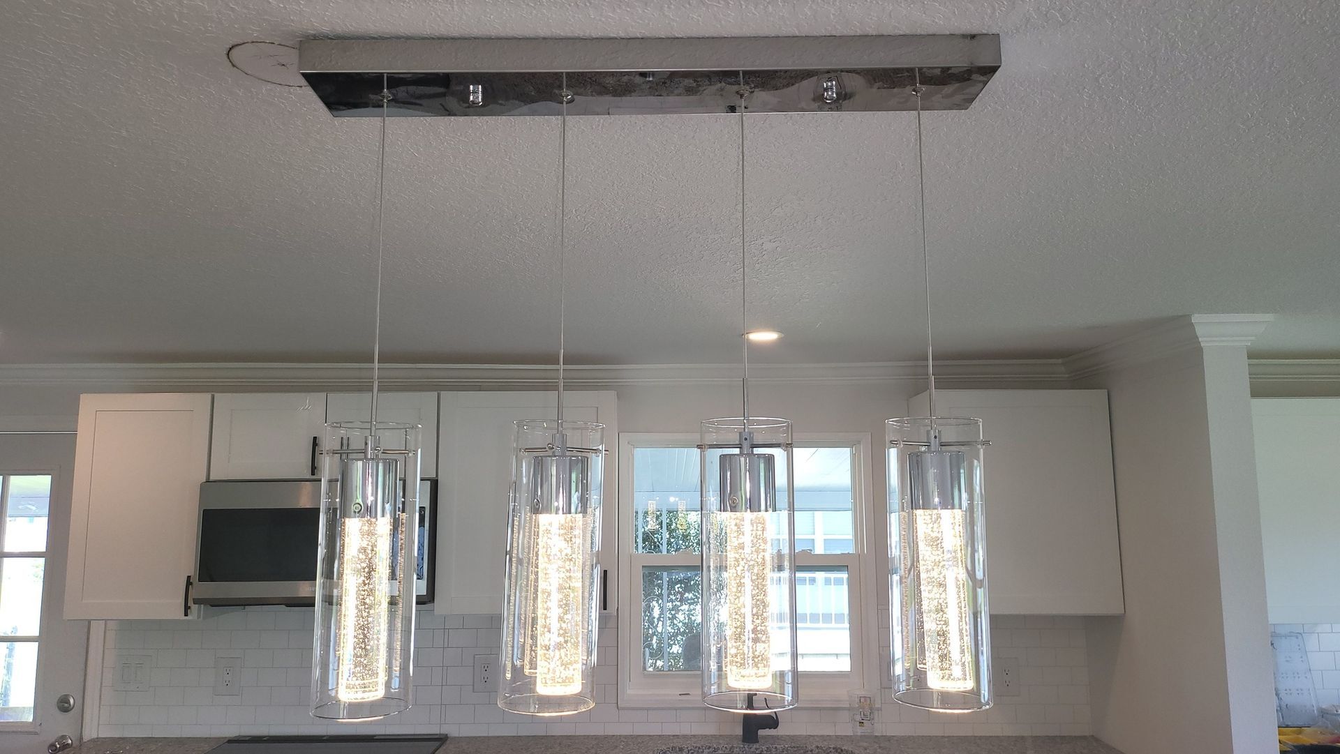 A kitchen with a chandelier hanging from the ceiling